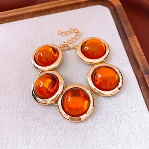 Bracciale vintage placcato oro con ciondoli circolari in resina ambra e chiusura a moschettone