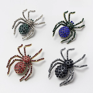 Detail view of four spider brooches with colorful rhinestones in gold and silver finish