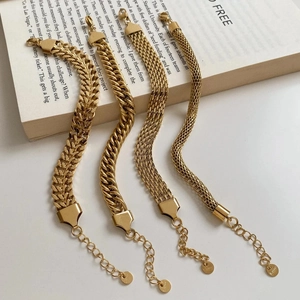 Set of four unique gold plated stainless steel bracelets for women on a book background