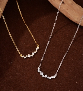 Detailed close-up of sparkling zircon curved pendant on elegant gold and silver chains