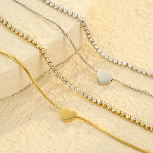 Elegant gold and silver heart pendant snake chains with zircon tennis bracelets on stone