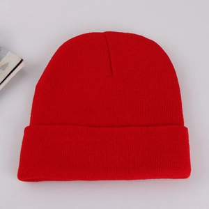 Detailed knit texture of a warm red winter beanie hat on a clean grey background