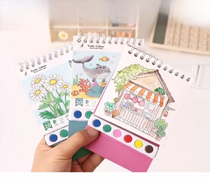 Close-up of portable watercolor paint book set with built-in palette and floral designs