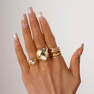 Detail of gold oval bean open rings with high-polished mirror finish on model hands