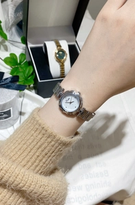 Close-up of Gostlie women's flower-shaped watch with silver steel band on wrist