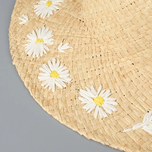 Macro detail of natural straw weave texture and delicate white daisy floral ornaments