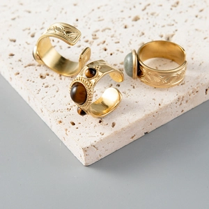 Close-up of three vintage gold rings with Celtic knots and green turquoise stones