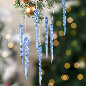 Detail of blue spiral glass icicle ornaments hanging on a snowy Christmas tree branch