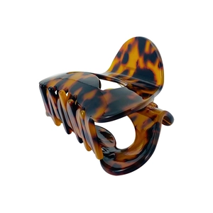 Detail of crescent moon hair claw clip featuring a brown tortoiseshell acetate texture