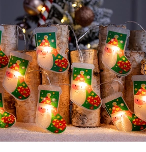 Détail de guirlandes LED chaussettes de Noël blanc chaud sur bois de bouleau et neige