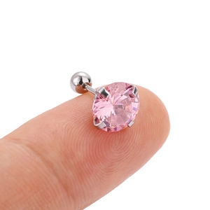 Macro shot of a pink zircon stud earring with a silver screw back held on a fingertip