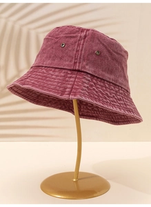 Détail du chapeau bob en denim délavé bordeaux avec œillets d'aération métalliques