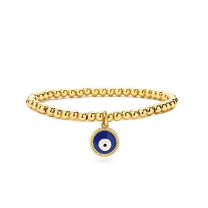 Detailed macro view of gold beaded bracelet featuring a blue enamel evil eye charm