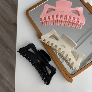 Vue détaillée de grandes pinces à cheveux nśud en rose, blanc crème et noir chic