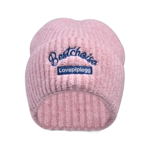 Close-up of pink knit beanie with detailed blue 'Bestchoice' letter embroidery and fuzzy texture