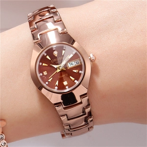 Détail d'une montre femme en or rose avec cadran marron et index en strass sur le poignet