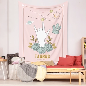 Detailed view of pink Taurus zodiac tapestry with floral accents hanging in a bedroom setting