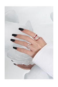 Detail of silver S925 rings with red enamel and zircons against ice background