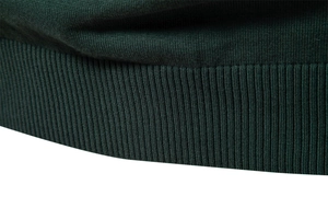 Macro shot of the ribbed hem texture on a dark green knitted sweater for men