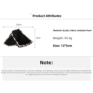 Détail d'une pince à cheveux triangulaire en tissu noir avec bordure élégante en perles