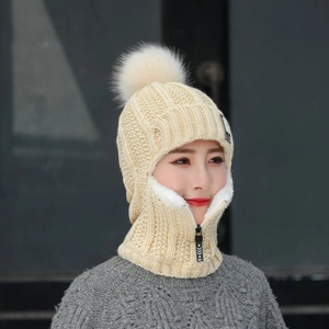 Détail de l'écharpe à capuche en maille beige avec pompon en fourrure et fermeture éclair