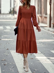 Robe midi caramel avec corsage plissé et ourlet à volants sur une rue d'automne
