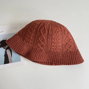 Close-up of caramel knit fisherman hat featuring vintage cable stitch texture and ribbed edge