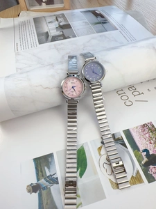 Detailed view of women's quartz watches with pink and blue dials and silver steel straps