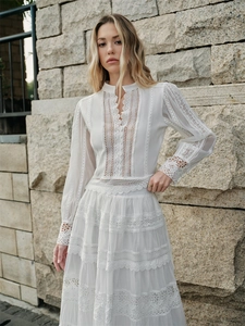 Elegant white French-style lace maxi dress with long sleeves and tiered hollow-out details