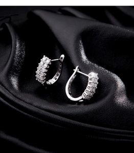 Macro shot of U-shaped S925 silver hoop earrings featuring triple-row pave zircon stones