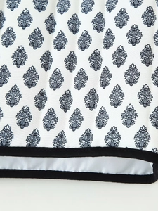 Detail of leaf print cotton fabric with black piping and quilted leaf pattern texture