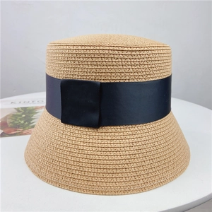 Women's woven straw bucket hat with navy grosgrain ribbon and bow for beach vacations