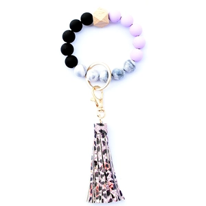 Detail of beaded keychain bracelet with silicone beads, wooden hexagonal bead and leopard tassel