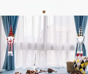 Détail d'une paire d'attaches de rideaux de gnomes de Noël avec des motifs à carreaux
