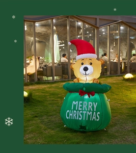Detailed view of an inflatable Christmas bear with a green gift bag and built-in LED lighting