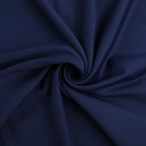 Gros plan sur la texture du tissu sergé bleu foncé avec un drapé doux pour robe courte