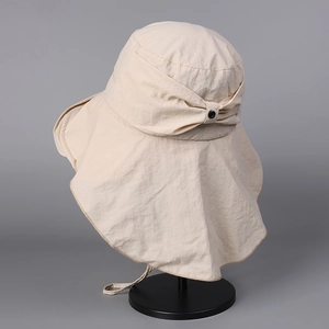 Detail of beige sun hat with back bow tie and chin strap on a mannequin stand