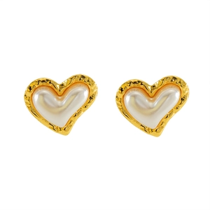 Boucles d'oreilles cœur en or rétro avec perle blanche et texture irrégulière sur blanc