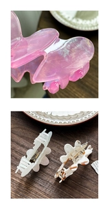 Detailed macro view of butterfly hair clips in pearl pink and amber acetate finishes