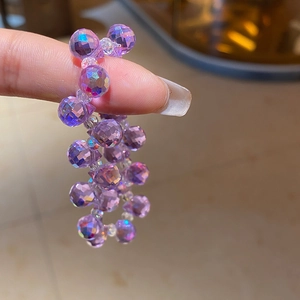 Detailed macro view of faceted purple amethyst crystal beads with an aurora AB coating finish