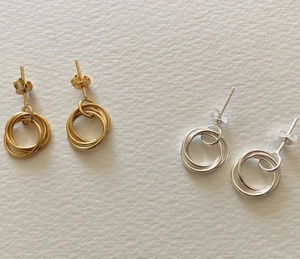 Close-up of minimalist S925 sterling silver triple interlocking hoop earrings in gold and silver
