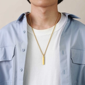 Male model wearing minimalist golden bar pendant necklace with wax rope cord
