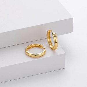 Macro shot of S925 sterling silver stamp on minimalist gold hollow huggie hoop earrings
