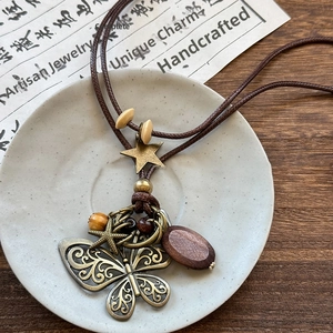Close-up of wood bead necklace with a vintage metal butterfly pendant and star charms
