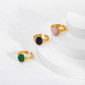 Detailed close-up of three vintage gold adjustable rings with green, blue, and pink stones