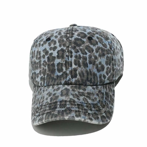 Detail shot of blue washed denim baseball cap with dark leopard print and stitched eyelets
