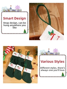 Detail of green knitted Christmas stocking with white cuff and red embroidered letter