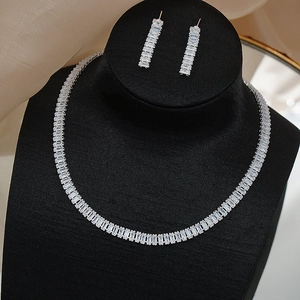 Close-up of bridal jewelry set with rectangular zircons on black neck display