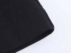 Gros plan détaillé sur la texture du tissu noir et les coutures de finition de la robe