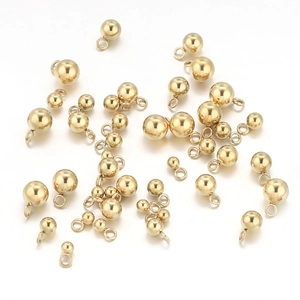 Macro shot of assorted golden stainless steel round ball pendants for jewelry making